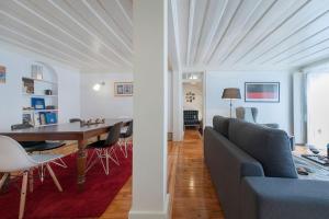 uma sala de estar e de jantar com um sofá e uma mesa em CHARMING 2 BEDROOM APARTMENT AVENIDA DA LIBERDADE em Lisboa