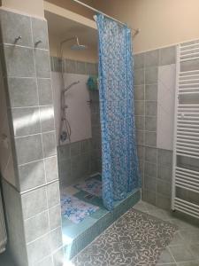 a shower with a blue shower curtain in a bathroom at appartamento vale in Viareggio