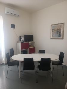 una sala riunioni con tavolo e sedie bianchi di appartamento vale a Viareggio