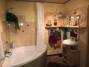 a bathroom with a tub and a sink at Ferienwohnung-Willgeroth in Ilsenburg