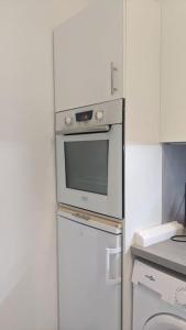 een keuken met een magnetron en een koelkast bij joli studio T2 meublé de 20 m² Située à 2 minutes à pied du MÉTRO in Marseille