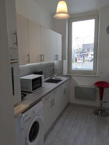 a kitchen with a sink and a microwave and a window at joli studio T2 meublé de 20 m² Située à 2 minutes à pied du MÉTRO in Marseille