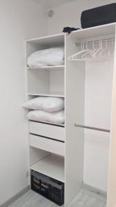 a white closet with white towels on shelves at joli studio T2 meublé de 20 m² Située à 2 minutes à pied du MÉTRO in Marseille