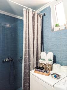 a bathroom with blue tiles and a shower curtain at Beautiful apartment in Chania in Chania
