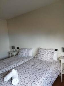 a bedroom with a bed with a white comforter and pillows at Rua as Neves in Malpica