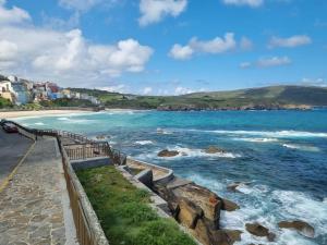 a view of a beach with buildings and the ocean at Rua as Neves in Malpica +4 photos