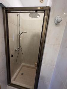 um chuveiro com uma porta de vidro na casa de banho em Chambre privée avec salle d’eau et terrasse au calme em Le Cannet