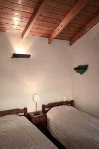 een slaapkamer met 2 bedden en een houten plafond bij Abrigo dos Bodes - Goat's Shelter in Calheta