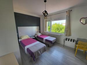 1 dormitorio con 2 camas y ventana en Gîte VENITIA, en Aussonne