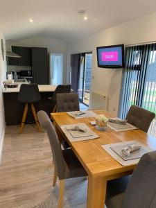 een eetkamer met een houten tafel en stoelen bij The Stables 