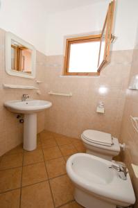 y baño con aseo y lavamanos. en AIR Borgo della Torre, en Isola Rossa