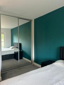 - une chambre dotée d'un miroir mural avec un lit et un miroir dans l'établissement Modern 1 bedroom apartment with parking in Colindale, London, à Colindale