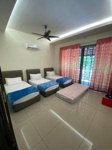a room with two beds and a ceiling fan at 15PAX 3 BR, Kids Swimming Pool, Pool table, BBQ near Spice ARENA, Airport Penang in Bayan Lepas