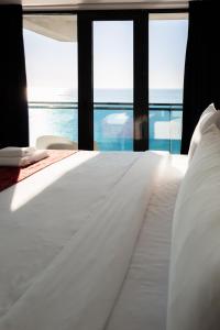 a white bed with a view of the ocean at Kartuli Hotel in Batumi