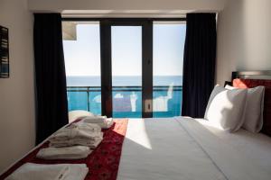 a bedroom with a bed with a view of the ocean at Kartuli Hotel in Batumi