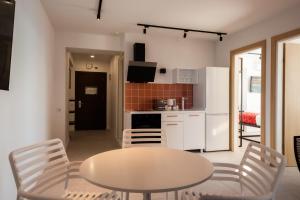 a kitchen and dining room with a table and chairs at Kartuli Hotel in Batumi