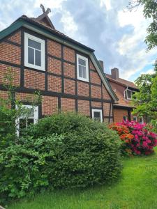 a brown brick house with white windows and flowers at Kleine Auszeit in Bad Fallingbostel