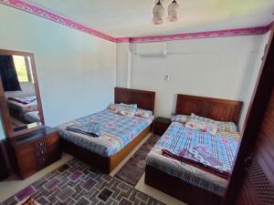 Habitación con 2 camas y espejo. en حجز شاليه غرفتين ورسيبشن بمارينا دلتا, en Al Ḩammād