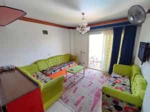 sala de estar con sofá y mesa en حجز شاليه غرفتين ورسيبشن بمارينا دلتا, en Al Ḩammād