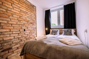 a bedroom with a brick wall and a bed at Apartament Miejski Chill in Toruń