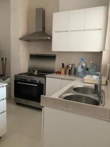 a kitchen with a sink and a stove at CHEZ RIMA // Studio très chaleureux F1 // Très bien situé in Dakar