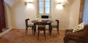 um quarto com uma mesa e cadeiras e uma janela em La Voûte Noble em Saint-Saturnin