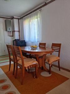 a dining room table and chairs with a table and a window at Lana apartman Pijavice in Jajce