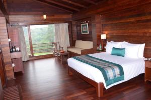a bedroom with a large bed and a balcony at GReaT Trails Kodaikanal by GRT Hotels in Kodaikānāl +48 photos