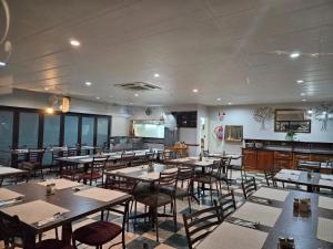 a restaurant with tables and chairs in a room at Pietersburg Lodge in Polokwane