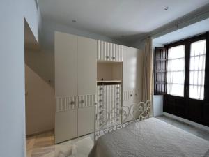 - une chambre avec un lit avec des placards blancs et une fenêtre dans l'établissement APARTMENT PALACIO DE LOS VIBORA, à Lucena