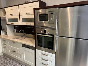una cocina con electrodomésticos de acero inoxidable y armarios blancos en APARTMENT PALACIO DE LOS VIBORA, en Lucena