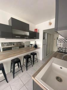 - une cuisine avec un comptoir et des tabourets dans l'établissement Studio 1 ère ligne Port Camargue, au Grau-du-Roi
