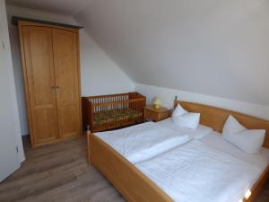 Schlafzimmer mit einem Bett und einem Holzschrank in der Unterkunft Ferienwohnung "Parkresidenz Concordia" - Wohnung 9 in Ostseebad Sellin