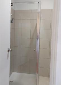 a shower with a glass door in a bathroom at Maruve Guesthouse 12 min from Melb airport in Melbourne