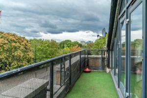 a balcony with green grass on the side of a building at Modern 1 Bedroom City Penthouse Apartment in London