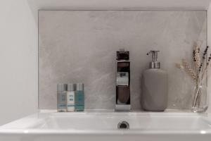 um lavatório com uma garrafa de sabão e um dispensador de sabão em Modern 1 Bedroom City Penthouse Apartment em Londres