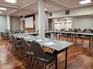 une salle de conférence avec des tables et des chaises et un tableau blanc dans l'établissement Hotel ARA - Dancing Club Restauracja ARA, à Jastrzębia Góra