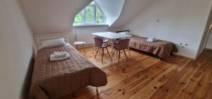 a room with two beds and a table with chairs at TREND HOUSE Apartments in Vinnytsya