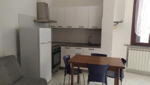 a kitchen with a wooden table and blue chairs at Accogliente appartamento Fucecchio in Fucecchio +23 photos