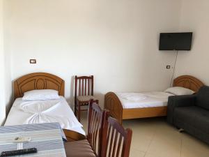 - un salon avec deux lits et un canapé dans l'établissement Arsen Apartments, à Saranda