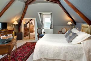 - une chambre avec un lit blanc et un miroir dans l'établissement L'Esplanade, à Domme