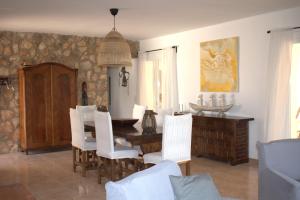 a dining room with a table and white chairs at Casa Nuria in L'Ampolla