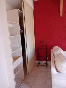 a room with a red wall and a white closet at La petite maison à la campagne / our little house in La Chapelle-Launay