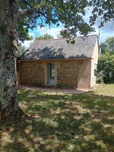 uma casa de tijolos com uma árvore em frente em La petite maison à la campagne / our little house em La Chapelle-Launay