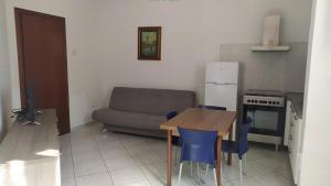 kuchnia ze stołem, niebieskimi krzesłami i kanapą w obiekcie Accogliente appartamento Fucecchio w mieście Fucecchio