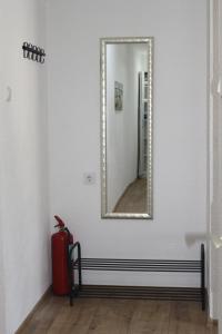 un miroir sur un mur à côté d'une valise rouge dans l'établissement Blue Apartment, à Bihać