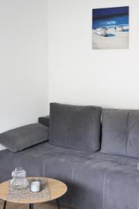 a living room with a gray couch and a table at Blue Apartment in Bihać