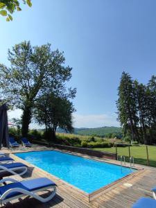 - une piscine avec des chaises longues à côté dans l'établissement Château du Pommoy, à Roussillon-en-Morvan