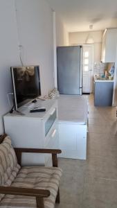 a kitchen with a desk with a television and a refrigerator at Ionian Dream Home in Vráchos