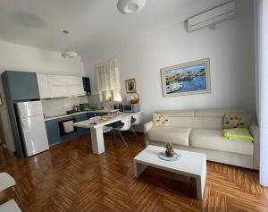 a living room with a couch and a kitchen at Port Side Sarande in Sarandë